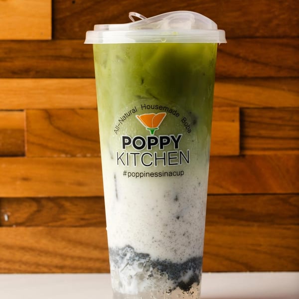 A Poppy Kitchen boba drink with green tea, white milk, and dark boba pearls.