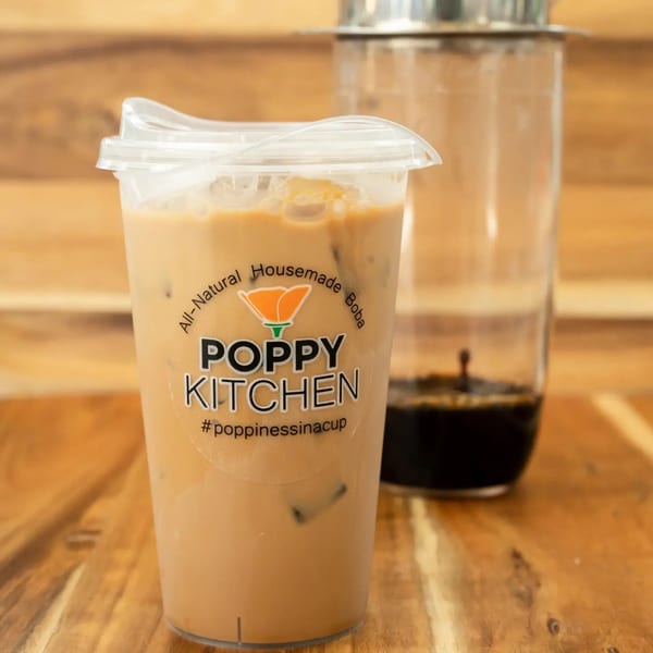 Iced Vietnamese coffee in a Poppy Kitchen cup next to a glass with dark coffee.